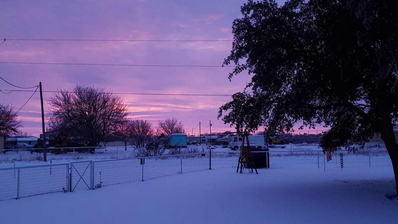 Early sunrise with magenta clouds over a snowy scene