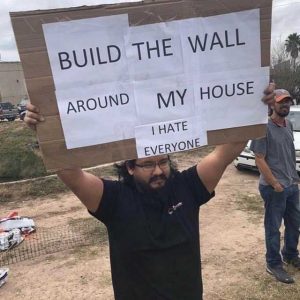 Man holding sign saying to build the wall around his house - he hates everyone