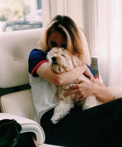 Woman cuddling medium sized dog