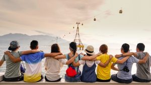 Line of people sitting on wall with arms on shoulders