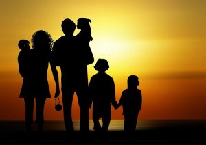 A family silhouetted in front of a sunset 