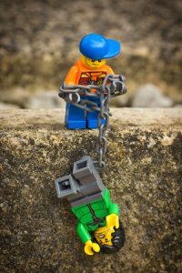 LEGO man rescuing another with chain