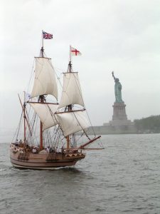 sailing ship in front of the statue of Liberty