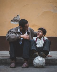 Man with arm around boy and soccer ball