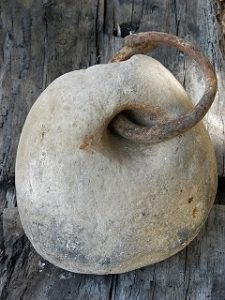 photo of a stone weight with an iron ring through a drilled hole