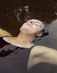 Woman floating on her back in water.